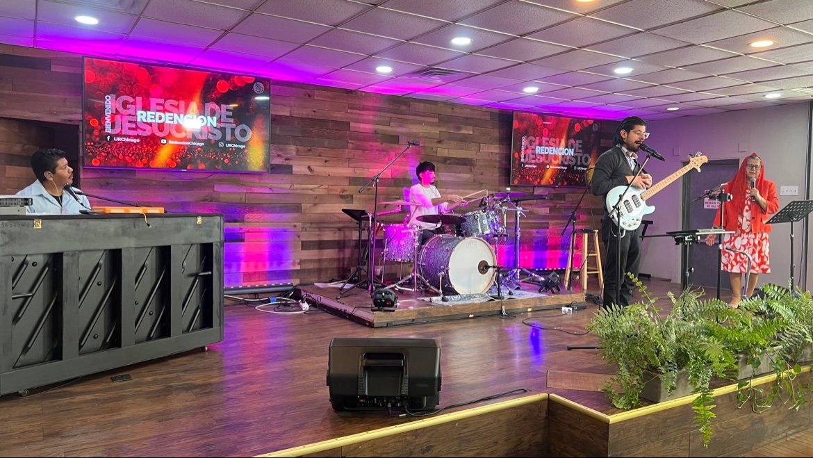 El grupo de alabanza tocando piano, batería y bajo en la plataforma