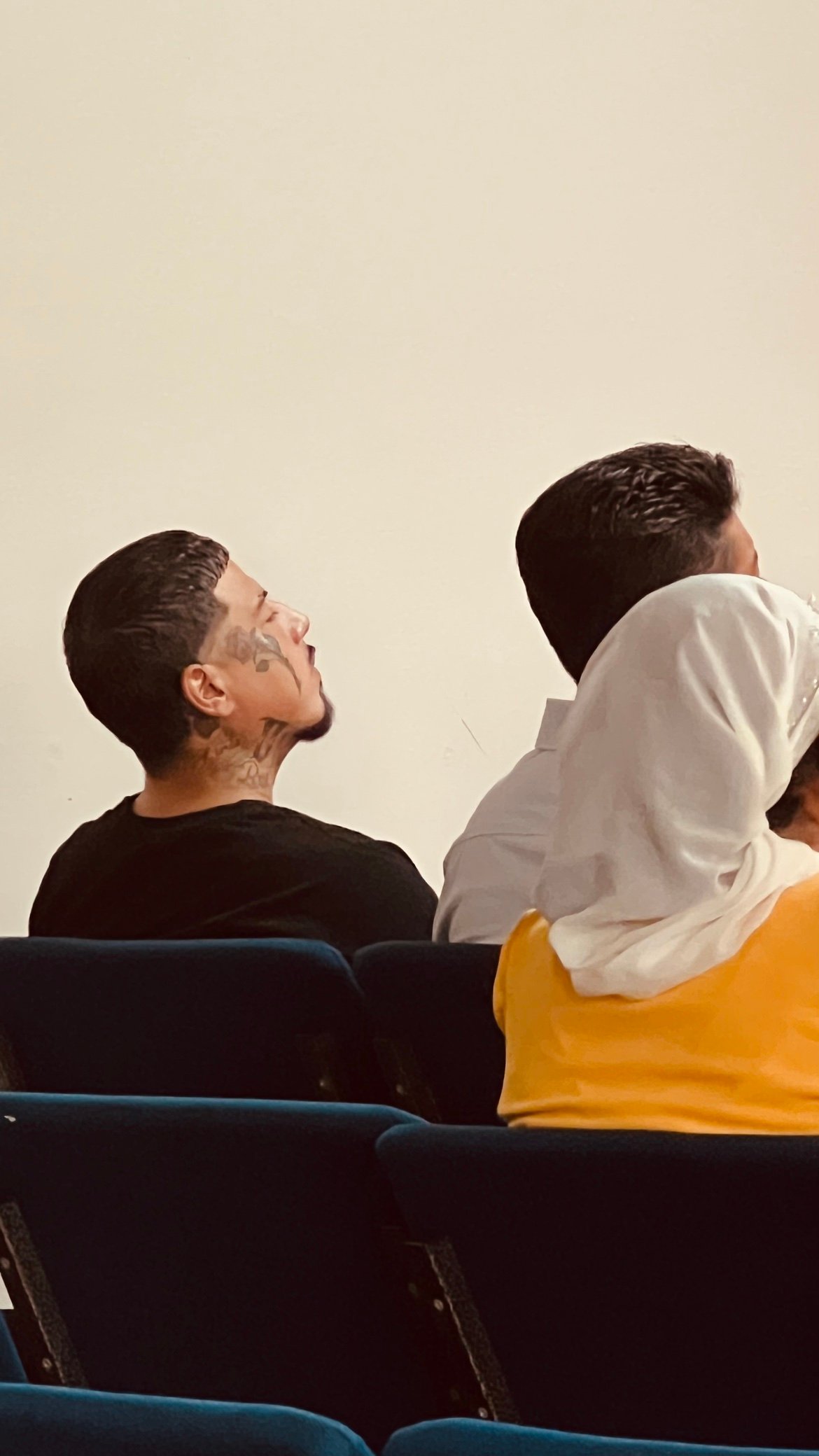 Un hermano sentado entre la congregación con los ojos cerrados, escuchando el servicio